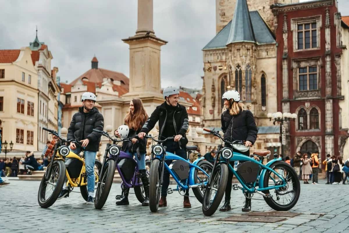 Four riders with colourful café-racer e-bikes on Old Town Square